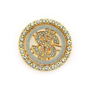 Macro detail of a round dollar sign brooch with rhinestones and gold plating