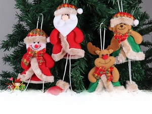 Detail of Christmas tree plush ornaments featuring Santa, snowman, elk, and bear hanging on branches