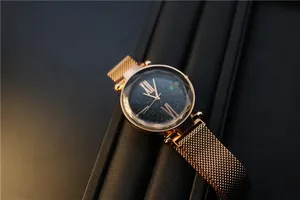Detail of rose gold magnetic mesh watch band and navy starry sky dial with Roman numerals