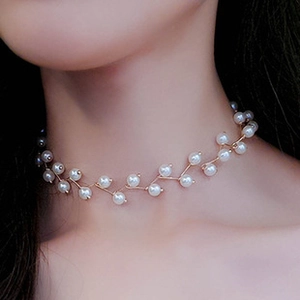 Close-up of elegant gold leaf branch choker featuring delicate micro white pearls on a model
