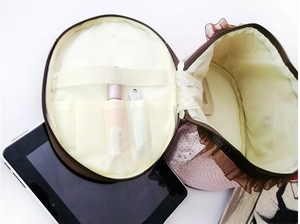 Detailed interior of a round polka dot makeup bag showing slots for lipstick and brushes