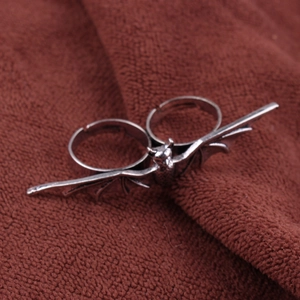 Detailed close-up of an antique silver bat-shaped double-finger adjustable ring design