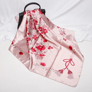 Pink floral satin square scarf draped over a black handbag as a stylish accessory