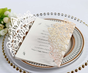 Detailed laser-cut wedding invitation with blue glitter and white floral lace patterns