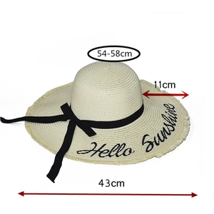 Close-up of Hello Sunshine embroidery and fringe edge on beige woven sun hat