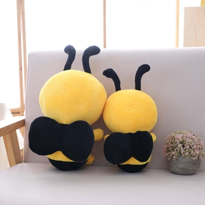 Simpatici cuscini di api in peluche a strisce gialle e nere su un divano grigio