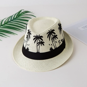 Detailed texture of ivory woven straw fedora hat with printed black palm tree patterns