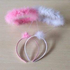 Detail of pink and white feather halo headbands on a rustic wooden background