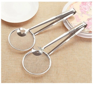 Detail von zwei Edelstahl-Frittierclips mit feinmaschigem Sieb auf beiger Matte