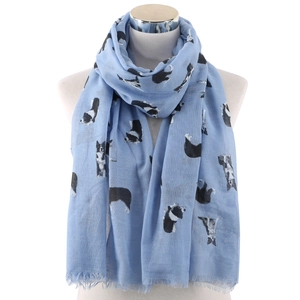 Close-up of lightweight blue scarf with sheepdog print and fringe tassels on a mannequin