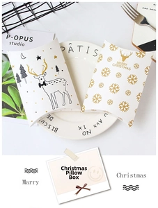 Close-up of elegant Christmas pillow gift boxes with gold reindeer and snowflake patterns