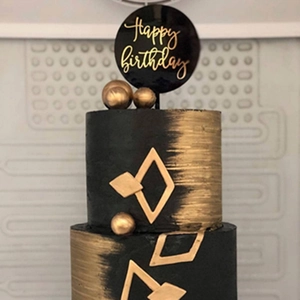 Detail of round double-layer black and gold acrylic Happy Birthday cake topper