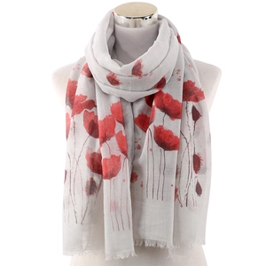 Detail of grey lightweight scarf featuring red poppy floral prints and tassel edges