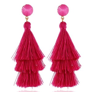 Fashionable long three-tier fuchsia tassel earrings with gold-tone resin top on white background
