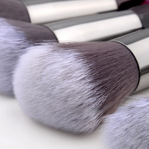 Macro detail of gray gradient synthetic bristles and silver metal ferrule on makeup brush