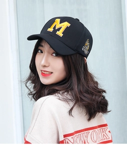 Detail of black baseball cap featuring yellow letter M embroidery and tiger side patch