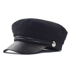 Classic black baker boy hat with leather peak and silver button detailing on white background