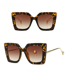Detailed front and side views of leopard cat eye sunglasses with gold pearl temples