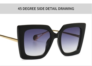 Detail view of large black square sunglasses with purple gradient lenses and gold temples