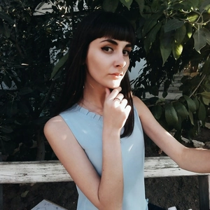 Close-up of a stainless steel ring and delicate necklace on a woman in a blue chiffon top