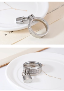 Detailed view of silver ring featuring a hanging lock pendant and pavé-set zircons