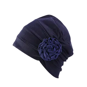 Détail d'un turban violet élégant avec fleur 3D multicouche et texture en maille plissée