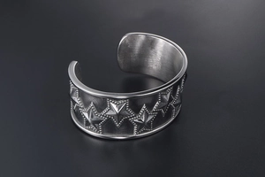 Close-up of vintage punk steel bracelet featuring embossed stars and beaded edges
