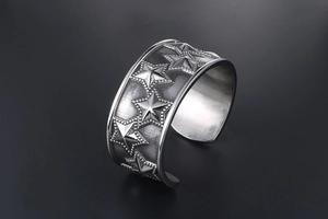 Detailed view of punk star pattern and vintage texture on wide stainless steel bangle
