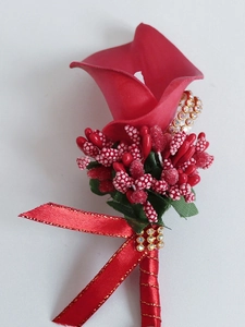 Detailed close-up of red calla lily boutonniere with gold ribbon and rhinestone accents