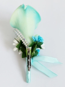 Detail view of teal calla lily boutonniere with rhinestone chain and silver safety pin