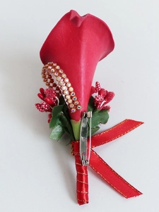 Detail of red calla lily boutonniere with rhinestone trim, berries, and satin ribbon