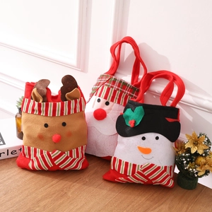 Three Christmas felt gift bags featuring Santa, snowman, and reindeer on a wooden surface