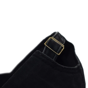Detail of adjustable metal buckle and cotton fabric texture on black baseball cap