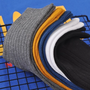 Five pairs of men's business crew socks in assorted colors on a black grid rack
