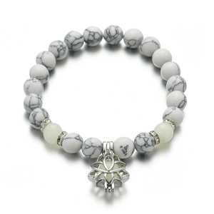 Detailed macro view of marble textured white beads and lotus charm yoga energy bracelet