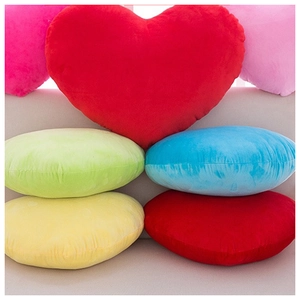 Colorful plush heart and round pillows on sofa for home decor and holiday gifts