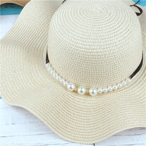 Elegant beige wide brim straw sun hat with decorative pearls and brown ribbon for beach