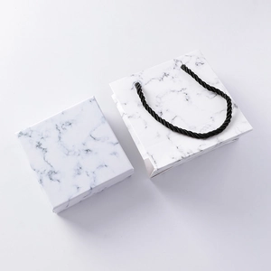 Scatola regalo minimalista in marmo bianco e sacchetto di carta abbinato con manico