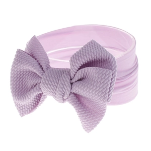 Macro shot of light purple nylon baby headband with soft ribbed texture and large bow