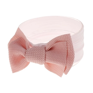 Close-up of light pink infant nylon headband featuring waffle texture and large bow