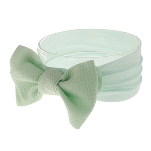 Close-up of mint green waffle texture nylon baby headband with a large bow detail