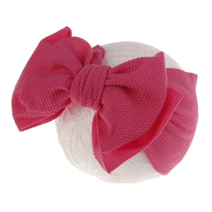 Detailed macro view of the soft waffle texture on a vibrant pink baby bow headband