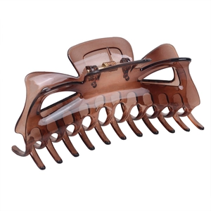 Detailed side view of a large amber hair claw clip with strong golden metal spring