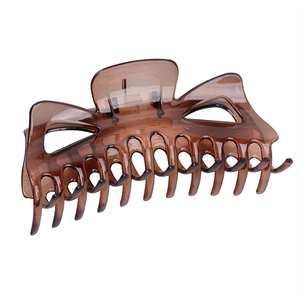 Detailed view of a translucent amber large claw clip with a multi-tooth hair grip design