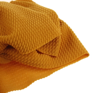 Close-up of bright yellow waffle knit fabric with 3D honeycomb texture on soft baby headband