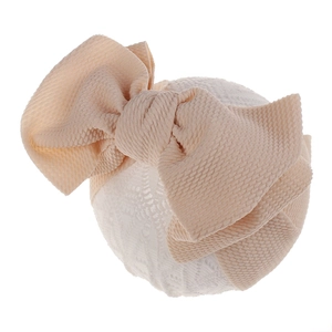 Close-up of beige waffle knit texture bow on a white elastic baby headband for infants
