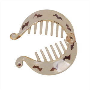 Close-up of amber resin banana hair clip with dark leopard pattern and PARIS logo