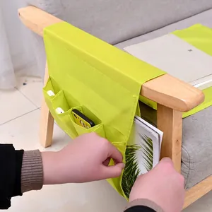 Green fabric bedside organizer bag with multiple pockets for remote and phone