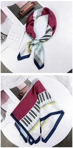 Detail of silk-feel scarf featuring piano key print and geometric color block design