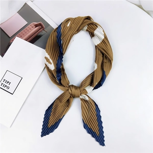 Détail d'un foulard en soie plissé marron avec des motifs abstraits bleus élégants